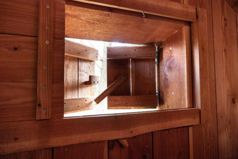 Vista interior de una pequeña ventana de madera en la tiny house Geurt, De Wije Werelt, Países Bajos, abierta.