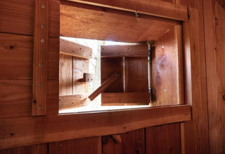Vista interior de una pequeña ventana de madera en la tiny house Geurt, De Wije Werelt, Países Bajos, abierta.