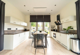 Moderne keuken bij Just Nature-lodge in De Wije Werelt, Nederland, met centraal kookeiland en helder interieur.