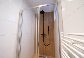 Douche moderne à Just Nature, De Wije Werelt, Pays-Bas, avec porte vitrée et pommeau pluie.