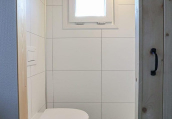 Petite salle de bain moderne de Tiny House at Buitenhuizen aux Pays-Bas avec toilette murale et fenêtre.