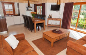 Moderne lodge med træmøbler og læderstole, store vinduer og hyggelig atmosfære i Nederlandene.