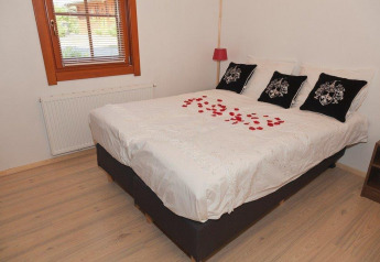 Gezellige slaapkamer bij Boekhorst Royal + Sauna, Brunssummerheide, Nederland, met rozenblaadjes op het bed.