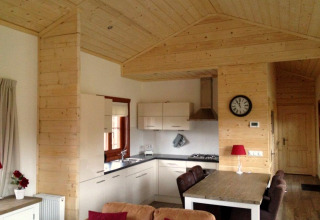 Interieur van een knusse houten lodge met moderne keuken en eetgedeelte in Boekhorst, Brunssummerheide.