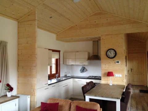 Vue intérieure d'un lodge en bois chaleureux avec cuisine moderne et salle à manger à Boekhorst, Brunssummerheide.