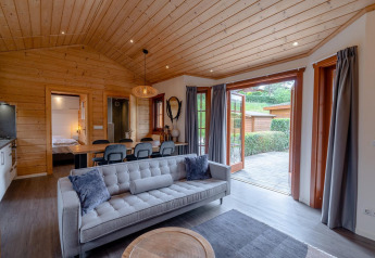 Gezellige lodge woonkamer Boekhorst, Brunssummerheide, Nederland, met houten afwerking en terras.