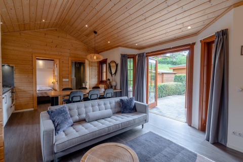 Salon lodge moderne Boekhorst à Brunssummerheide, Pays-Bas, intérieur bois chaleureux et accès terrasse.