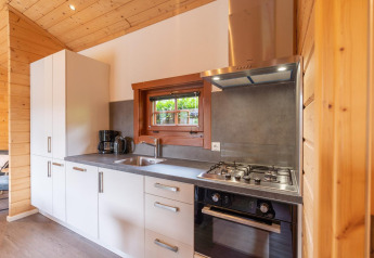 Moderne keuken in Boekhorst lodge bij Brunssummerheide, Nederland, met gasvuur en houten binnenafwerking.