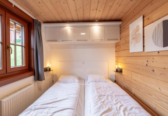 Gezellige tweepersoonskamer in Boekhorst lodge op Brunssummerheide, Nederland, met houten wanden.