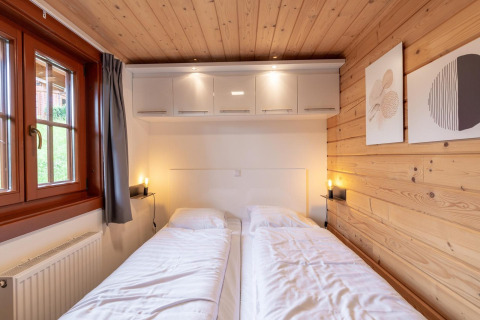 Chambre confortable avec lits jumeaux au Boekhorst lodge à Brunssummerheide, Pays-Bas, murs en bois.