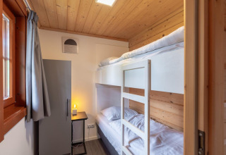 Stanza luminosa con soffitto in legno e letto a castello nel lodge Boekhorst a Brunssummerheide, Paesi Bassi.