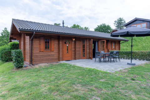 Chalet en bois à Boekhorst, Brunssummerheide aux Pays-Bas, avec terrasse, mobilier de jardin et pelouse.