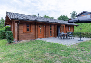 Houten lodge in Boekhorst, Brunssummerheide, Nederland, met terras, tuinset en omringend groen gras.