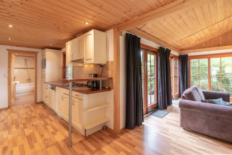 Lodge Boekhorst Royal chaleureuse, intérieur en bois, coin cuisine, salon et larges fenêtres à Brunssummerheide.