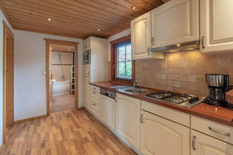 Cocina moderna de una cabaña Boekhorst Royal en Brunssummerheide, Países Bajos, con baño al fondo de la imagen.