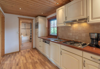 Cuisine moderne du lodge Boekhorst Royal à Brunssummerheide, Pays-Bas, vue sur la salle de bain en arrière-plan.