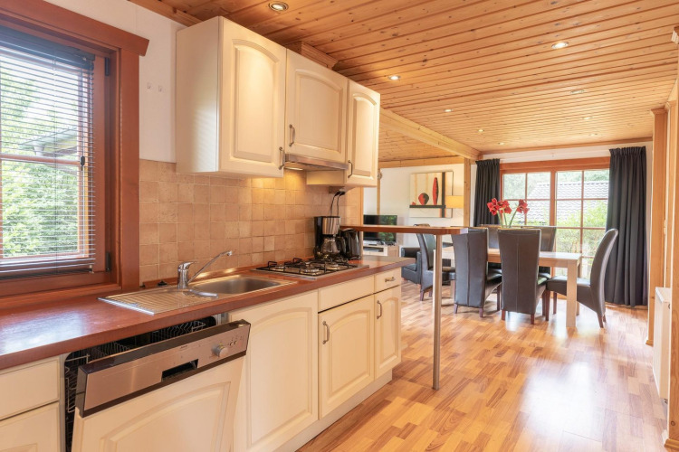 Acogedora cocina y comedor en una cabaña Boekhorst Royal, Brunssummerheide, Países Bajos, con madera.