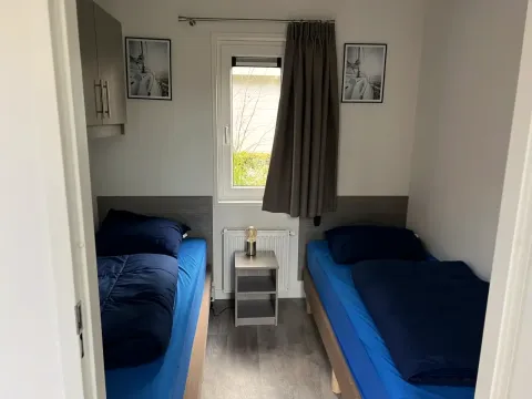Kamer in L-Pavilion op Brunssummerheide in Nederland met twee eenpersoonsbedden en moderne uitstraling.