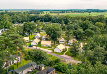 Luftfoto af Glampingtent på Reestervallei i Holland, omgivet af træer og åbne marker, ideel til naturferie.
