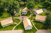 Luftbild von Glampingzelten bei Reestervallei in den Niederlanden, umgeben von grünen Bäumen.