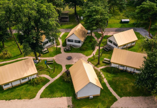 Vista aerea dei lodge Glampingtent a Reestervallei nei Paesi Bassi, circondati da alberi verdi.
