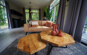 Stilfuld dagligstue i Just Nature-lodgen ved Reestervallei i Holland med træborde og moderne sofa.