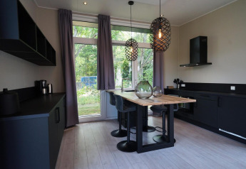 Cucina moderna e zona pranzo con grandi finestre al Just Nature lodge, Reestervallei, Paesi Bassi.