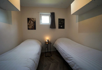Gemütliches Zimmer im Just Nature, Reestervallei, Niederlande, mit zwei Einzelbetten und stimmungsvoller Deko.