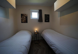 Gezellige kamer met twee eenpersoonsbedden, raam en kunst bij Just Nature, Reestervallei, Nederland.