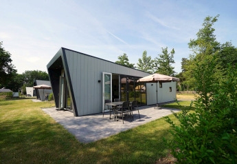 Modernes Just Nature-Lodge in Reestervallei, Niederlande, mit Terrasse, Garten und Sitzgelegenheiten.
