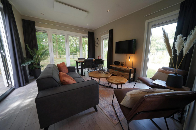 Lodge Just Nature Light en Reestervallei, Países Bajos, con grandes ventanales y elegante decoración moderna.