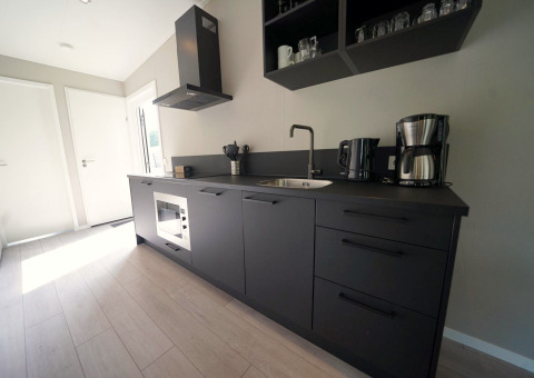 Cuisine noire moderne à la Just Nature Light lodge de Reestervallei, Pays-Bas, au design épuré et contemporain.