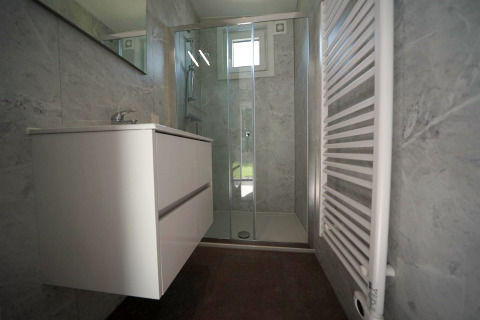 Salle de bain moderne au Just Nature Light lodge à Reestervallei, Pays-Bas, avec douche et lavabo.