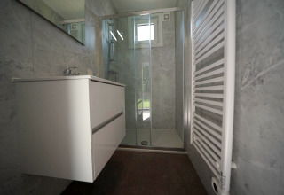 Salle de bain moderne au Just Nature Light lodge à Reestervallei, Pays-Bas, avec douche et lavabo.