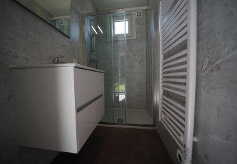 Moderne badkamer in Just Nature Light lodge te Reestervallei, Nederland, met douche en wastafel.