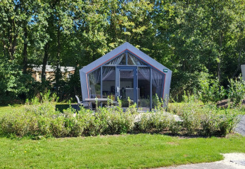 Foto des Tiny Houses Solo Retreat im Reestervallei, Niederlande, von Bäumen und Grün umgeben.