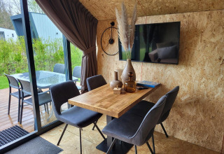 Zona pranzo moderna in una tiny house presso Solo Retreat, Reestervallei, Paesi Bassi, con vista terrazza.