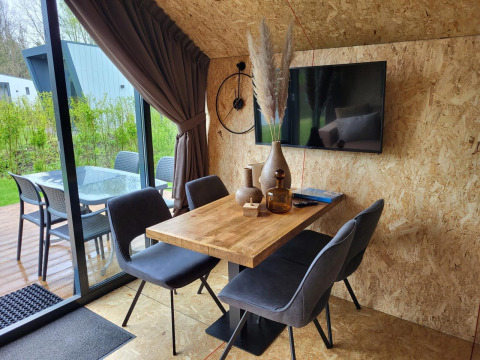 Zona pranzo moderna in una tiny house presso Solo Retreat, Reestervallei, Paesi Bassi, con vista terrazza.