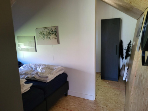 Camera da letto nella tiny house Solo Retreat a Reestervallei, Paesi Bassi, con letto e armadio.