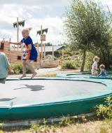 Niños juegan en camas elásticas integradas en el parque vacacional FarmCamps BoeBaDoe en Limburgo, Países Bajos.