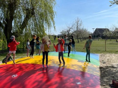 Niños juegan y saltan en un cojín inflable colorido en FarmCamps De Buitenhoeve, Gelderland, Países Bajos.