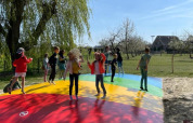 Children are jumping and playing on a colorful air cushion at FarmCamps De Buitenhoeve in Gelderland, Netherlands.