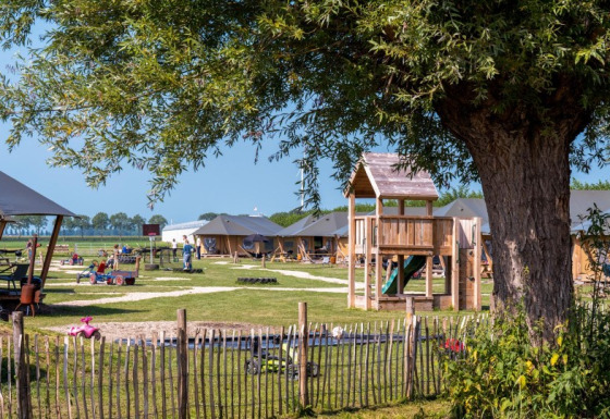 Speeltuin en tenten bij FarmCamps De Buitenhoeve in Gelderland, Nederland, kinderen spelen buiten.