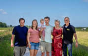 En familie poserer sammen på en gårdsti ved FarmCamps De Geele Bosch i Friesland, Holland, om sommeren.