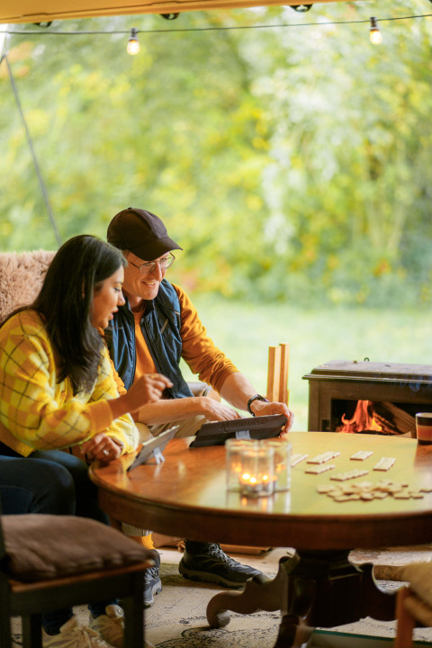 Dos personas juegan a un juego de mesa y disfrutan junto a la chimenea en RØSTIG Dorst, Brabante Septentrional.