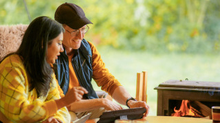 Zwei Personen spielen Gesellschaftsspiele am Tisch vor dem Kamin im Ferienpark RØSTIG Dorst in Brabant.