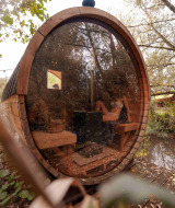 Sauna rond en bois avec façade vitrée au parc de vacances RØSTIG Dorst, entouré de nature en Brabant-Septentrional.