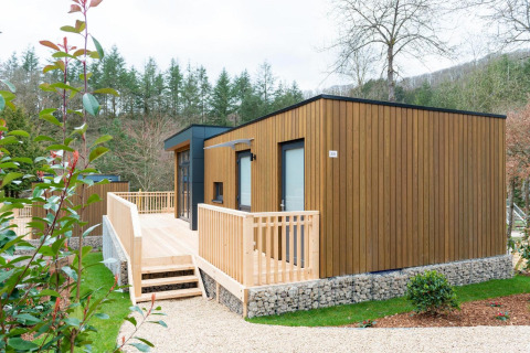 Moderne houten lodge met ruim terras en natuurlijke omgeving bij Cube La Mer vakantiepark.
