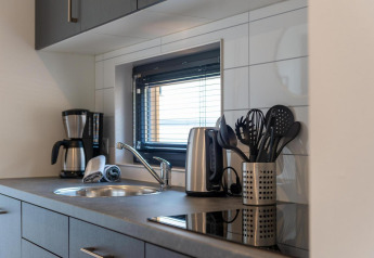 Moderne Küchenzeile in Cube La Mer, Kohnenhof, Luxemburg, mit Wasserkocher, Kaffeemaschine und Besteck.