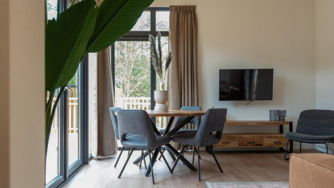 Moderne woonkamer in Cube La Mer-lodge in Kohnenhof, Luxemburg, met grote ramen en stijlvolle inrichting.
